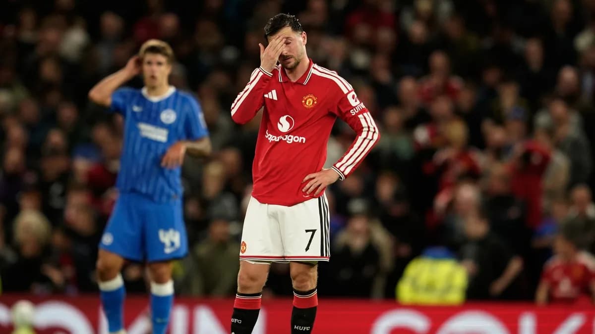 Manchester United number seven Mason Mount covers his face with Brighton players behind him