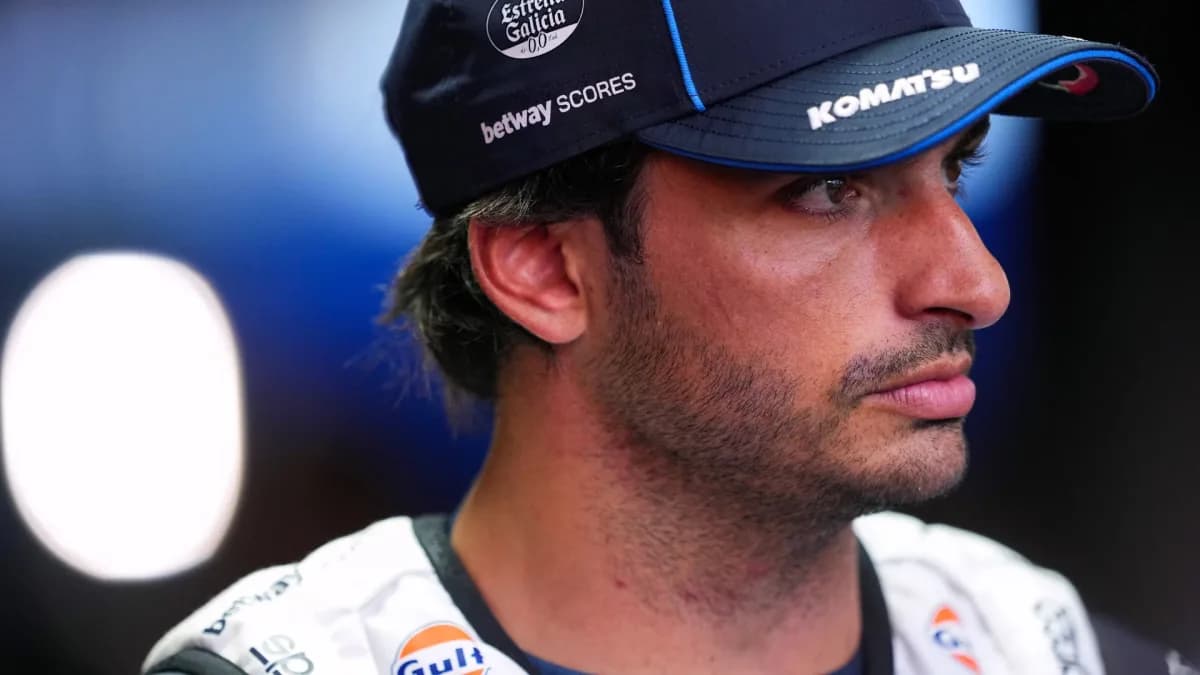 Carlos Sainz wears a blue Williams cap in a paddock portrait