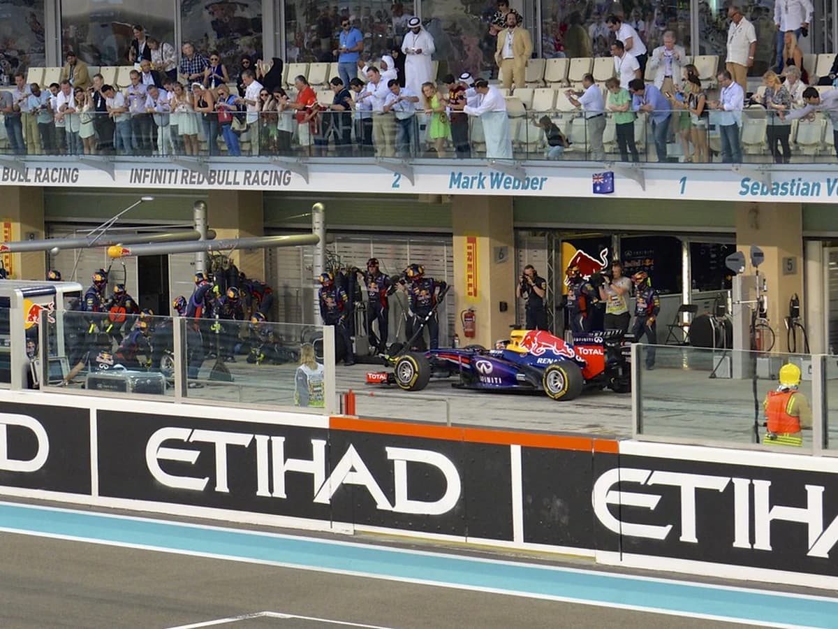 F1 pit crew celebrating in front of the team garage