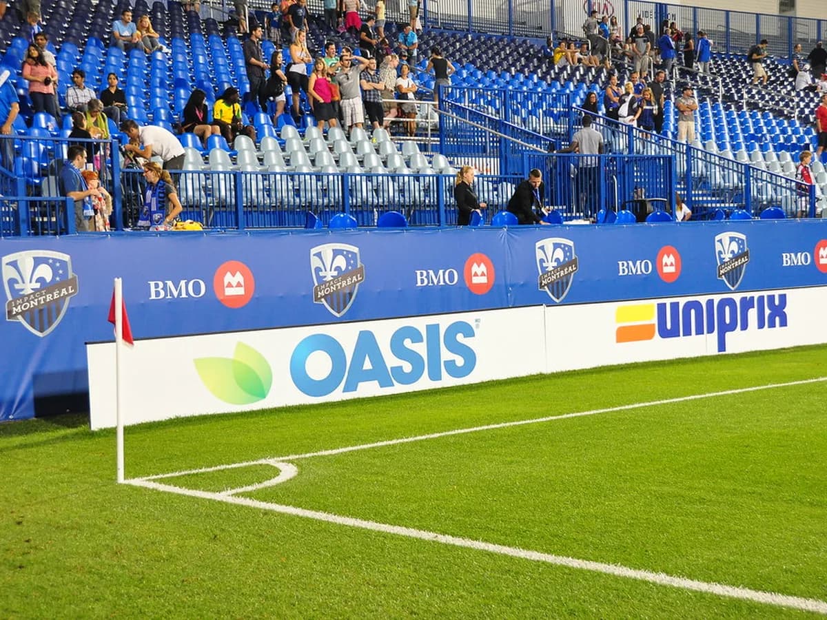 Football players challenging near the corner flag during a match