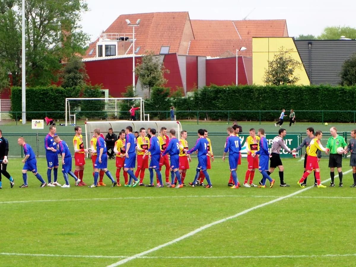 Two rival team captains shaking hands before a derby match