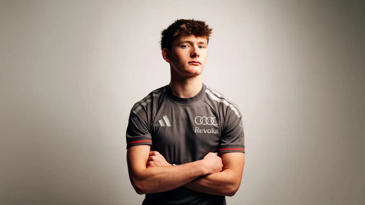 Freddie Slater poses with folded arms in a black Audi team shirt