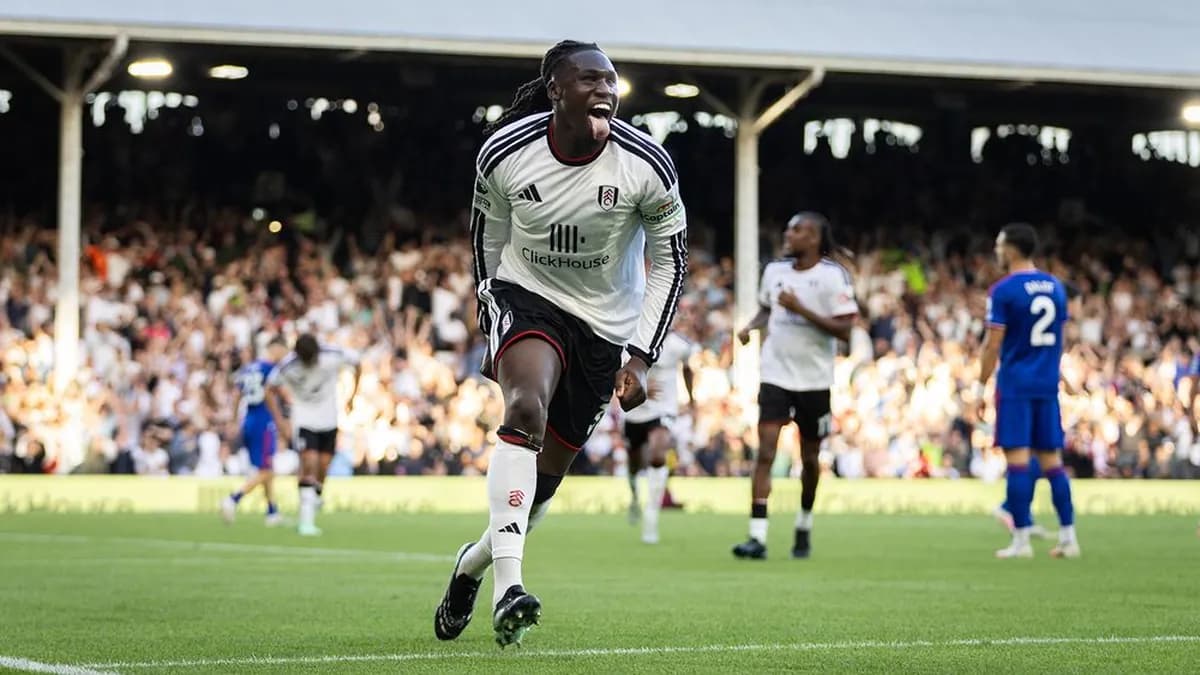 A Fulham player in the white home kit runs off celebrating in front of cheering fans at Craven Cottage during the 1-1 draw with Manchester United