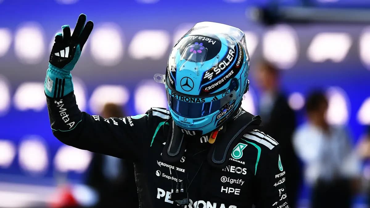 George Russell waves to the crowd in his light-blue Mercedes helmet and race suit after taking pole position in Baku