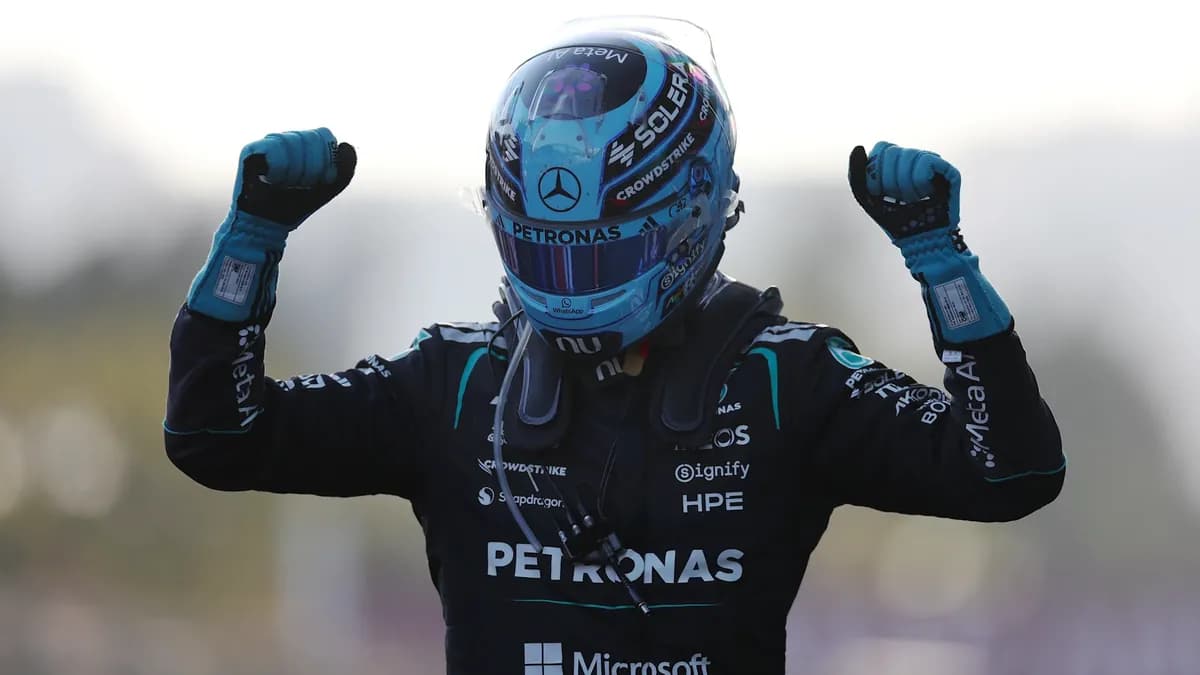 George Russell raises both fists in celebration wearing his light-blue helmet and Mercedes race suit after winning in Baku