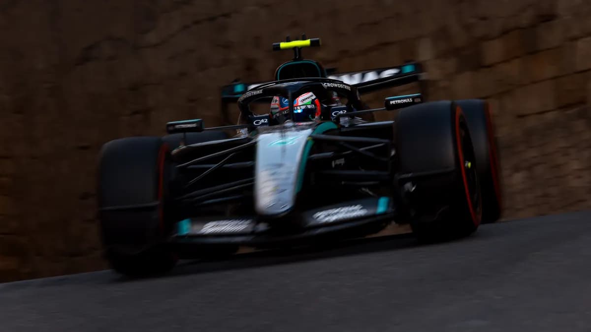 Kimi Antonelli drives his black and silver Mercedes on soft tyres past the old stone walls of the Baku street circuit