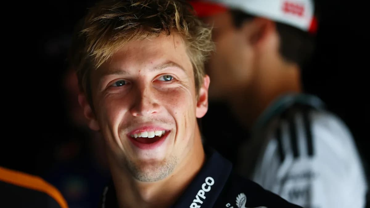 Liam Lawson smiles while wearing a black Red Bull team shirt