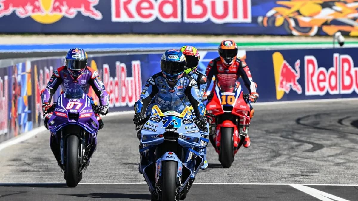 Alex Marquez on the number 73 Gresini Ducati leads a purple Yamaha and a red Honda along the pit lane in front of Red Bull advertising boards
