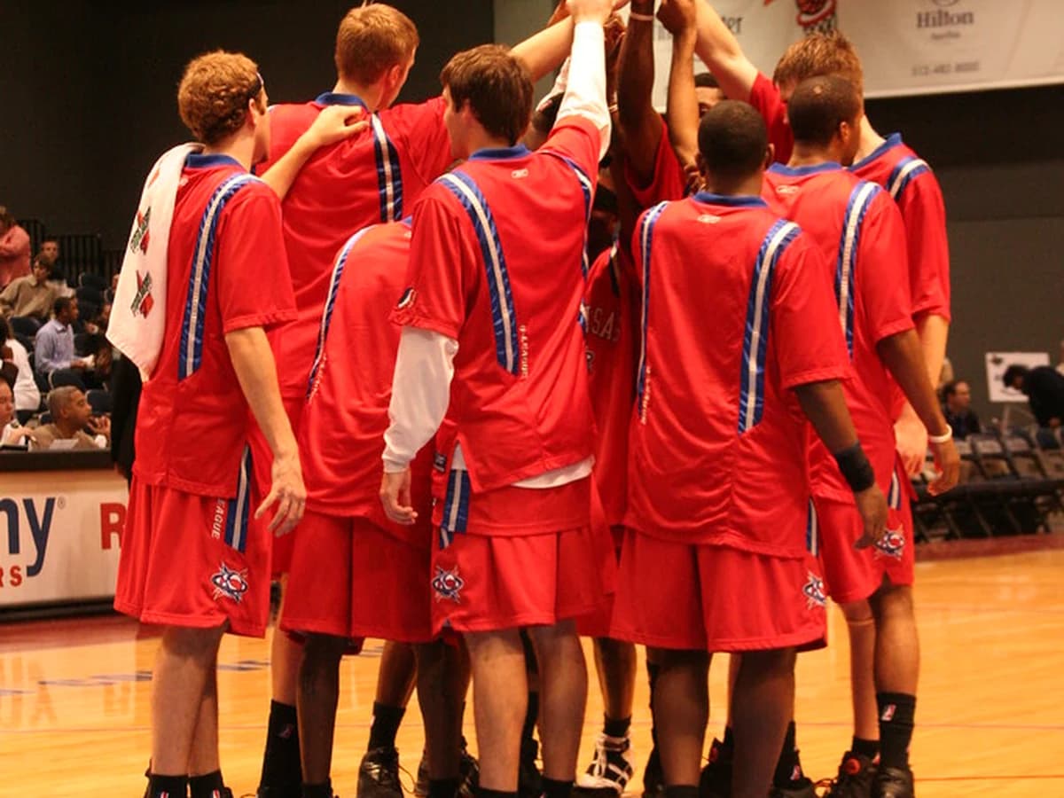 NBA coach reviewing a clipboard courtside during a timeout