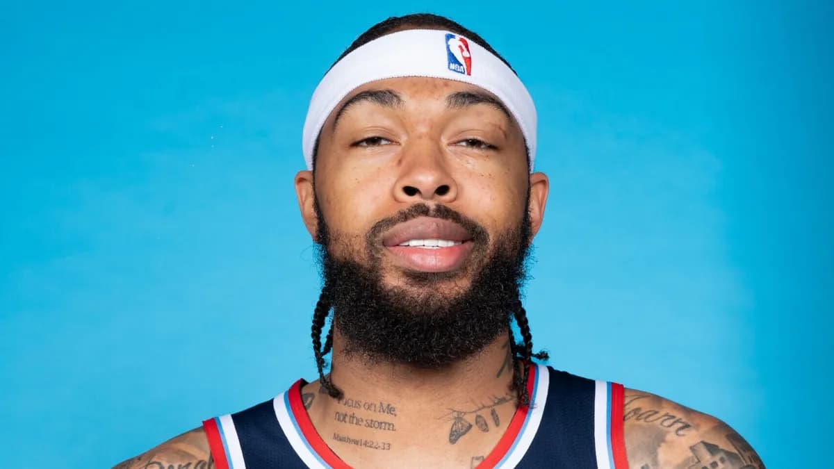 Brandon Ingram wearing a white NBA headband and navy LA Clippers jersey poses for a portrait against a blue backdrop