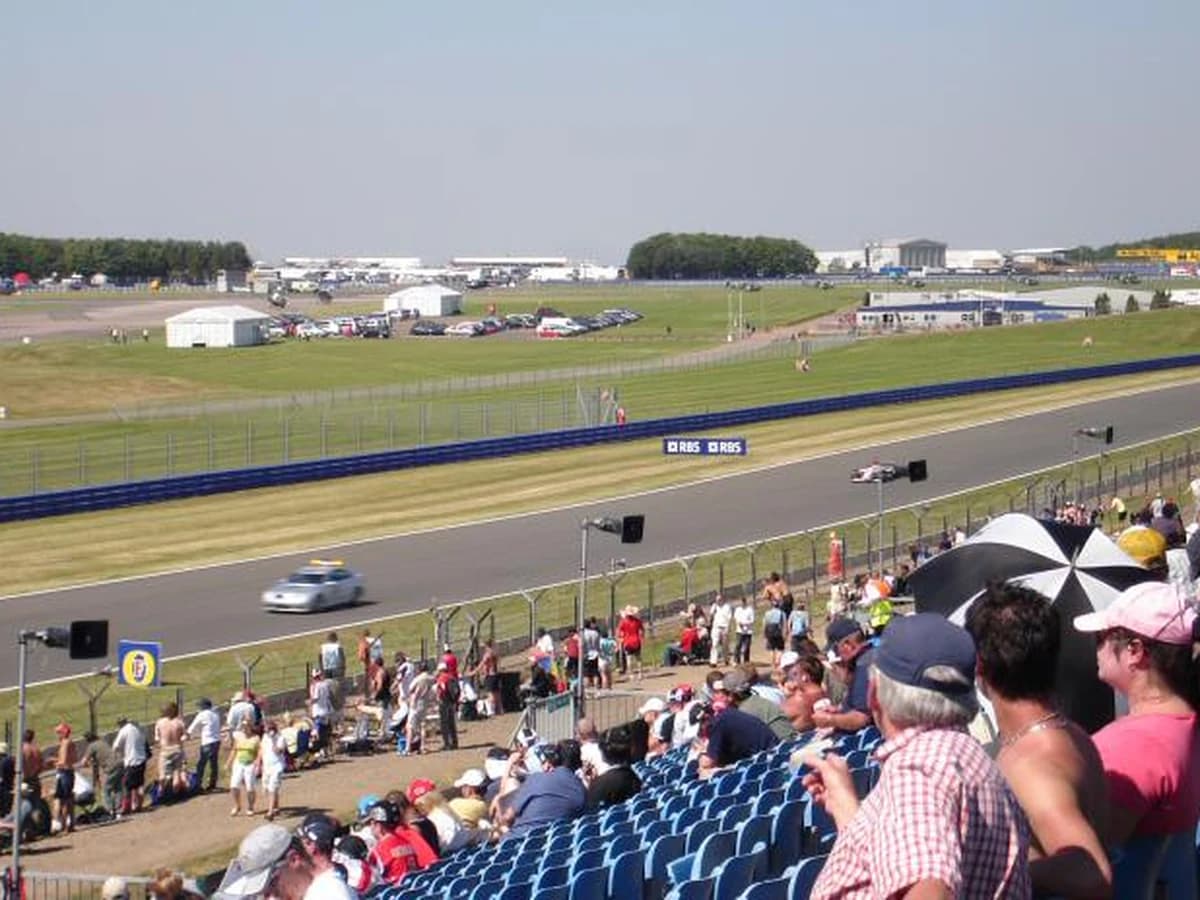 F1 car exiting a corner at speed, motion blur on the grandstand