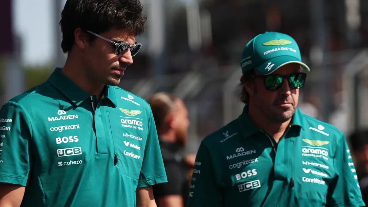 Lance Stroll and Fernando Alonso walk side by side in green Aston Martin team shirts and sunglasses in the paddock