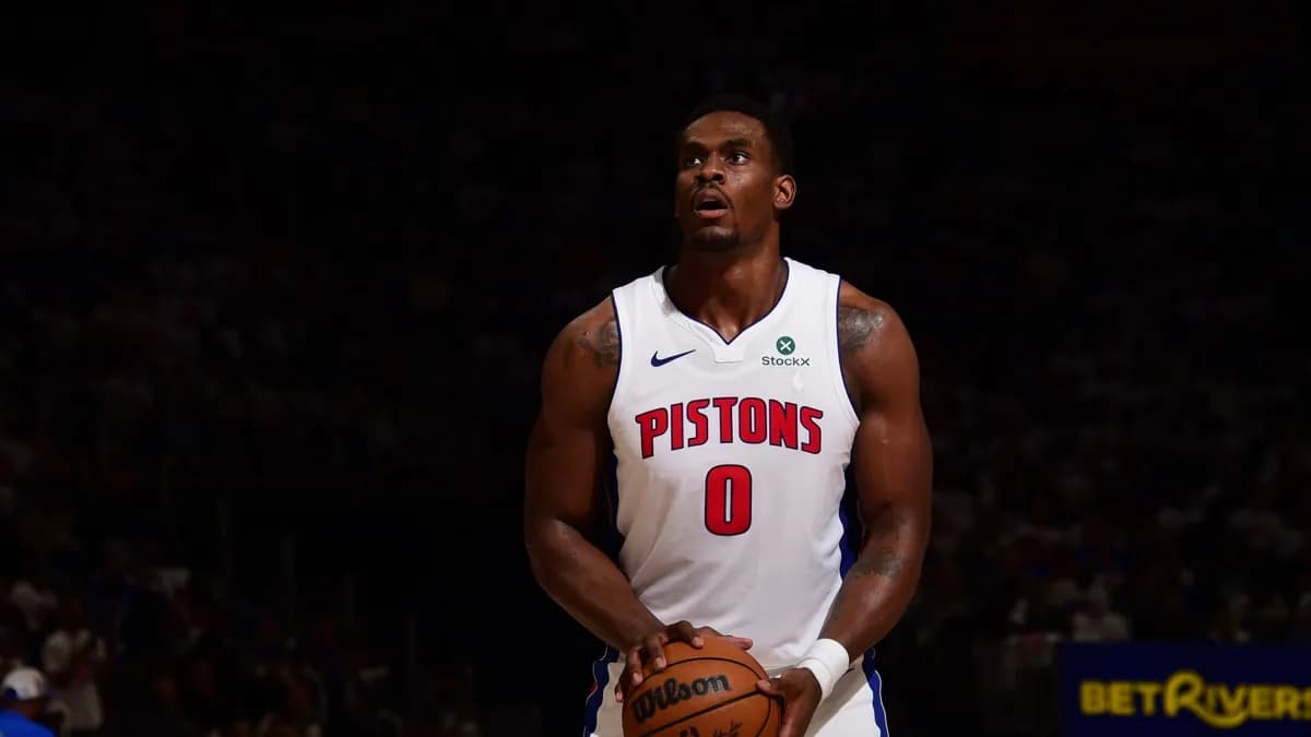 Jalen Duren holds the ball at the free-throw line in a white Detroit Pistons number 0 jersey during a game