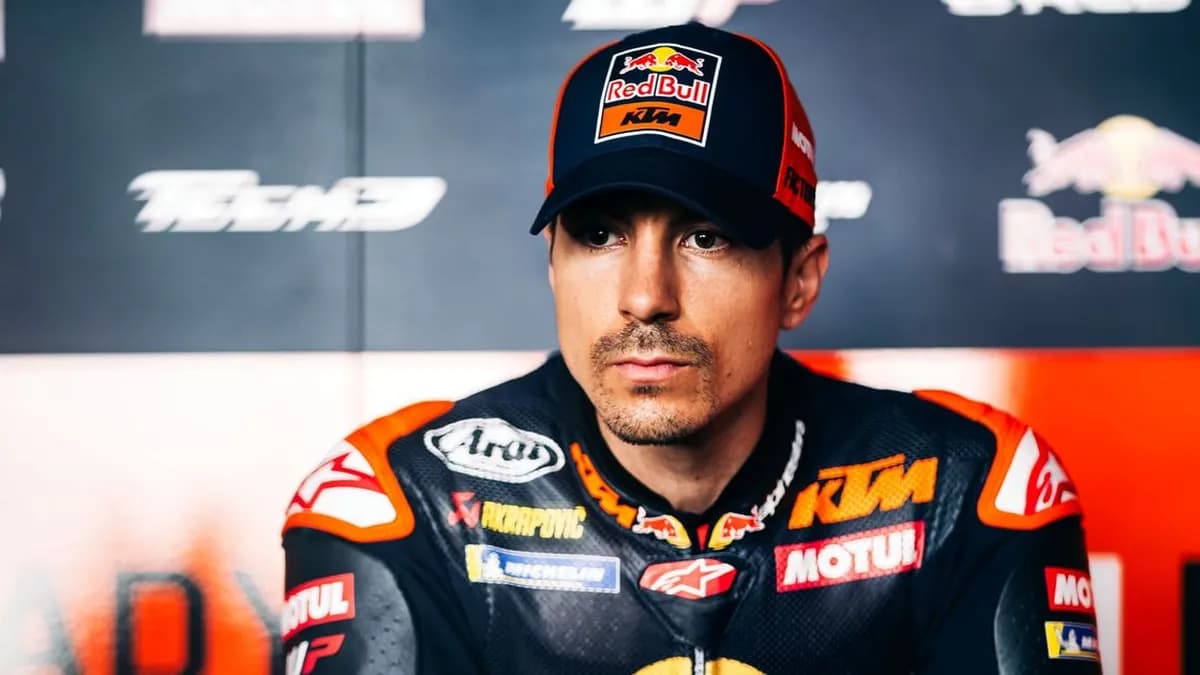 Maverick Viñales in a Red Bull KTM cap and team leathers sits in front of Tech3 branding with a calm, focused expression